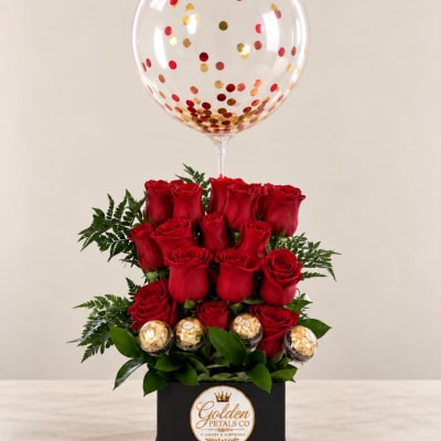 Red roses in a black box with a clear confetti balloon above