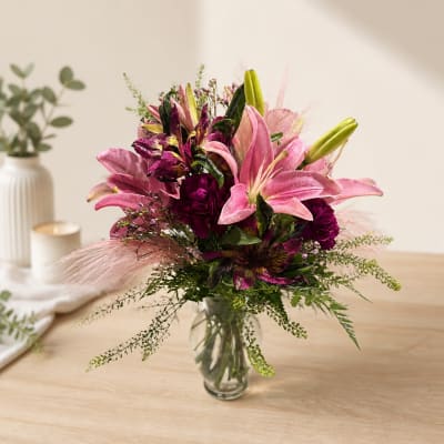 Pink and purple flower bouquet in a clear glass vase