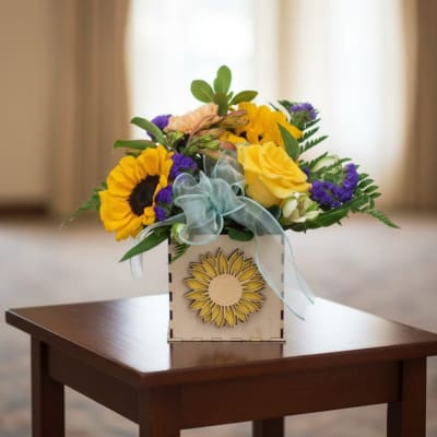 Sunflower and yellow rose arrangement in a wooden box with a blue ribbon