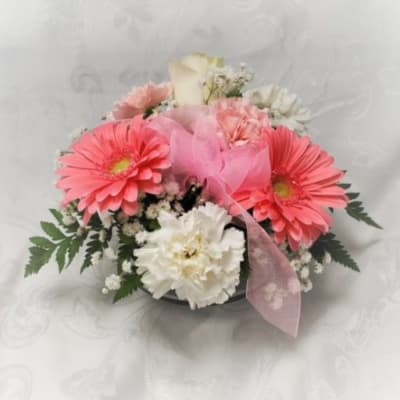 Pink and white flower arrangement with a pink ribbon on a white background