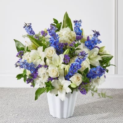 White and blue floral arrangement in a white vase