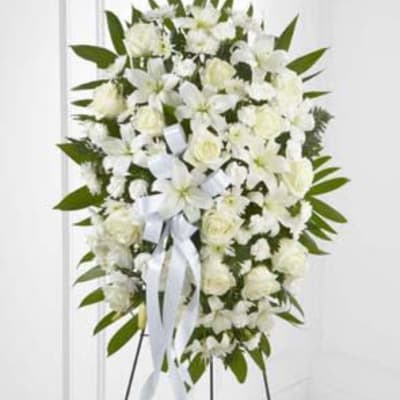 White floral standing spray with ribbon on an easel