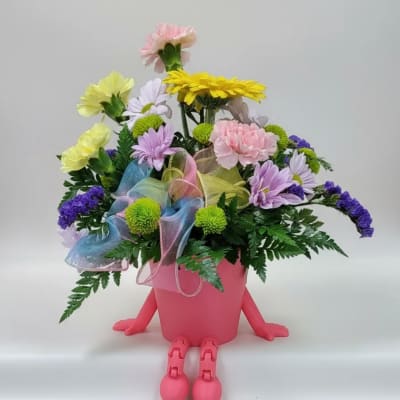 Colorful flower arrangement in a pink pot with small legs and arms