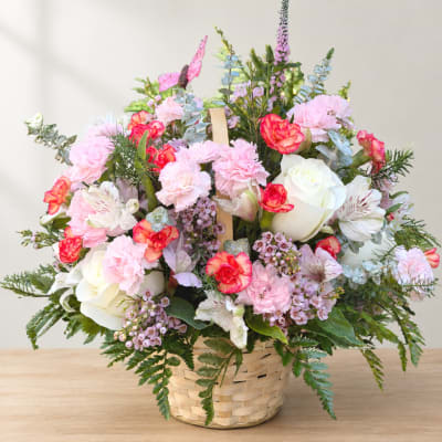 Pink and white flower arrangement in a woven basket