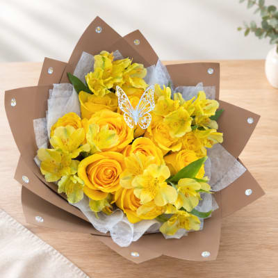 Yellow roses and alstroemeria bouquet wrapped in brown paper