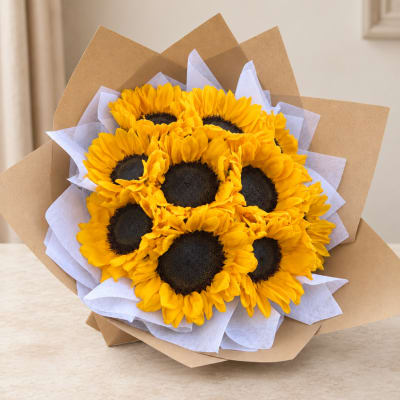 Bouquet of yellow sunflowers wrapped in brown paper