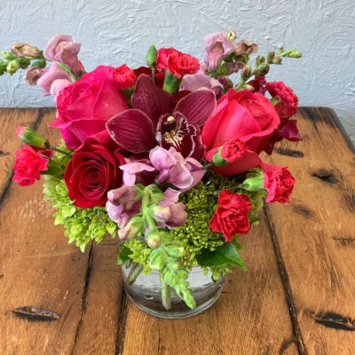 Pink and red flower arrangement in a clear glass vase