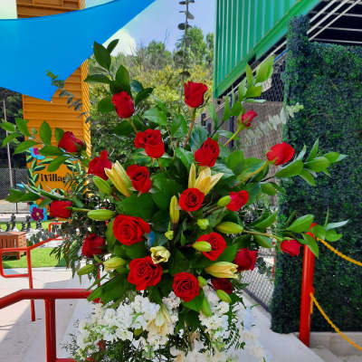 Tall standing floral spray with red roses, white blooms, and lilies