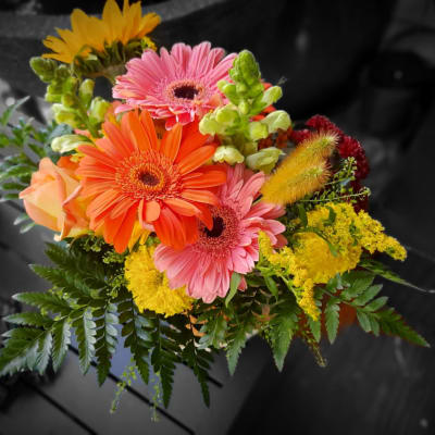 Bright mixed bouquet with gerbera daisies, roses, and yellow filler flowers