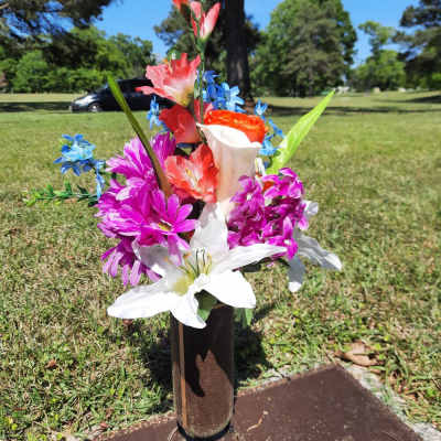 Colorful flower arrangement placed on a grave marker outdoors