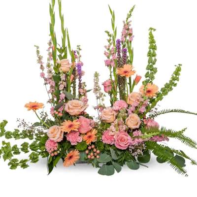 Pink and peach floral arrangement with tall green spikes and orange daisies