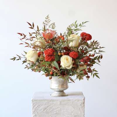 White and red floral arrangement in a silver vase
