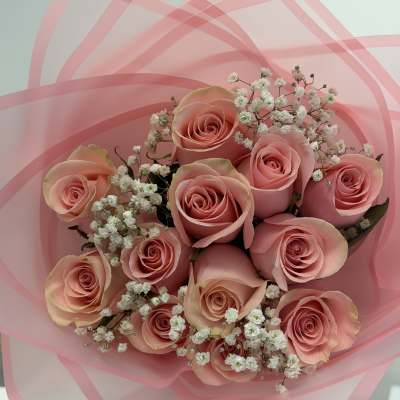 Bouquet of pink roses with white baby's breath in pink wrap