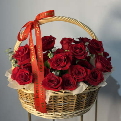 Basket of red roses with a red ribbon