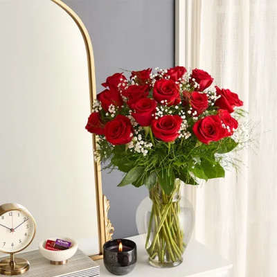 Bouquet of red roses in a clear glass vase with baby's breath