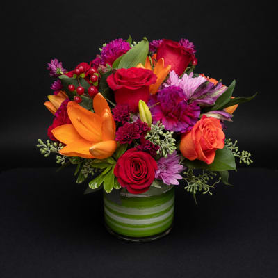 Colorful mixed bouquet in a green striped glass vase