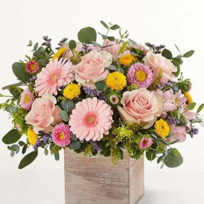 Pink roses and daisies arranged in a wooden box