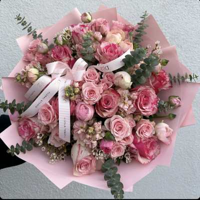 Pink rose bouquet wrapped in pale pink paper with ribbon