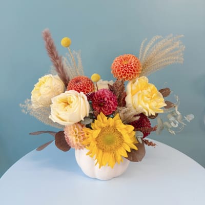 Mixed bouquet in a white vase with sunflowers, roses, and dahlias
