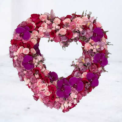 Heart-shaped floral arrangement with pink and red roses and purple orchids