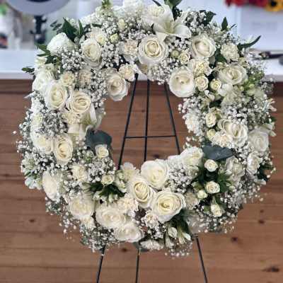 White rose wreath on a black stand