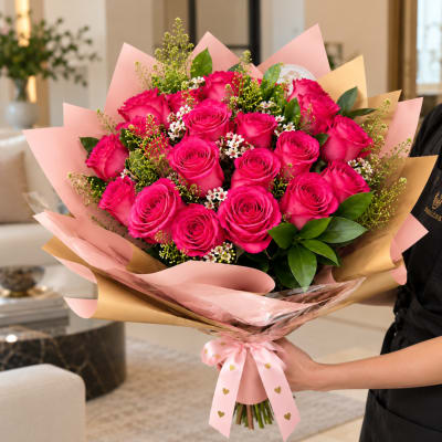 Bouquet of bright pink roses wrapped in pink and gold paper