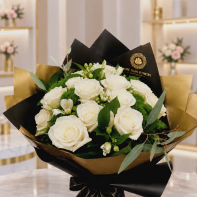 Bouquet of white roses wrapped in black and gold paper