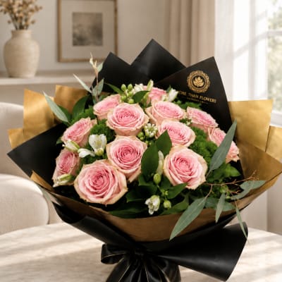 Bouquet of pink roses wrapped in black and gold paper
