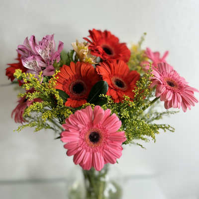 Pink and red gerbera daisies in a glass vase
