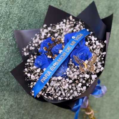 blue roses with trinkets and sash