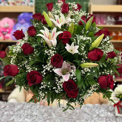 Large arrangement of red roses, white lilies, and baby's breath in a pedestal vase