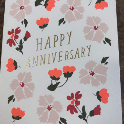 Happy anniversary greeting card with pink and red floral illustrations and gold lettering