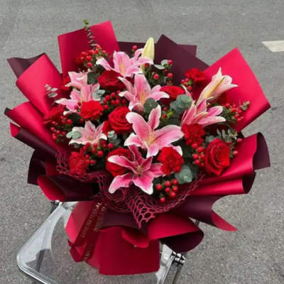 Bouquet of pink lilies and red roses wrapped in red paper