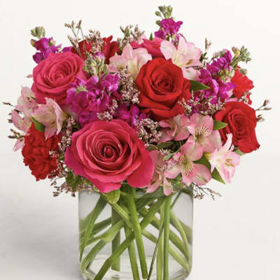 Bouquet of pink and red roses with pink alstroemeria in a clear glass vase