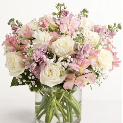 Pink and white bouquet of roses and lilies in a clear glass vase