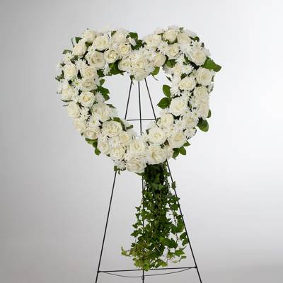 Heart-shaped standing wreath of white roses and daisies with a cascading ivy tail
