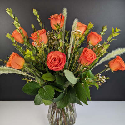 Orange roses arranged in a clear glass vase