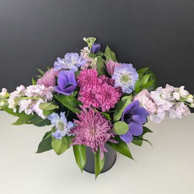 Purple and pink mixed bouquet in a gray vase