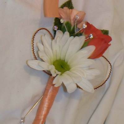 Small boutonniere with a white daisy and peach-orange flowers
