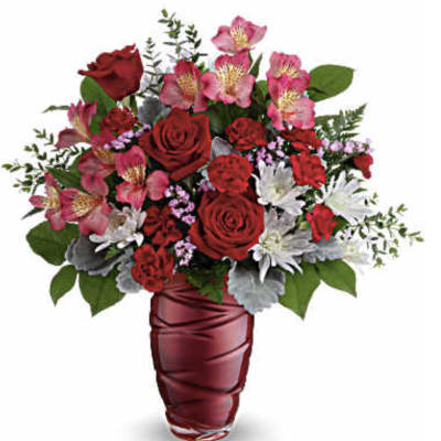 Red roses and pink alstroemeria in a red vase