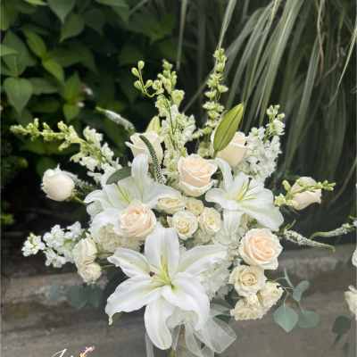 White lilies and cream roses in a clear vase