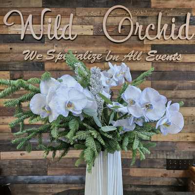 White orchid arrangement in a tall ribbed vase