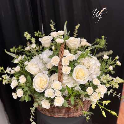 Basket arrangement of white roses and small white blooms