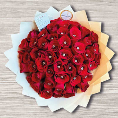 Bouquet of red roses wrapped in white and beige paper