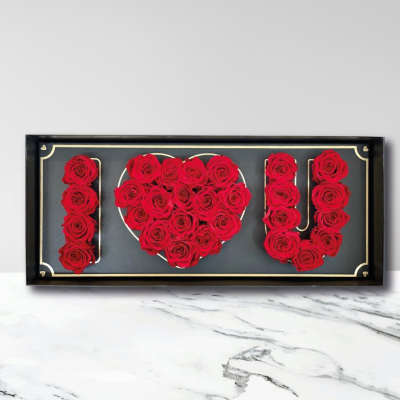 Red roses arranged to spell I love you in a black frame