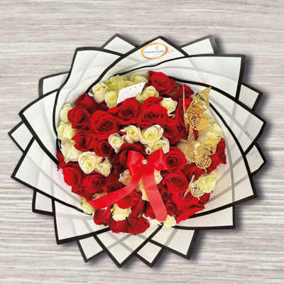 Bouquet of red and white roses wrapped in black-edged paper