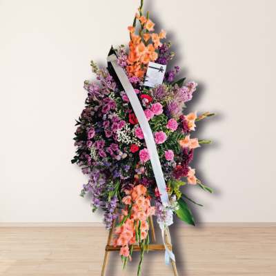 Standing floral spray with pink, purple, and peach flowers on an easel