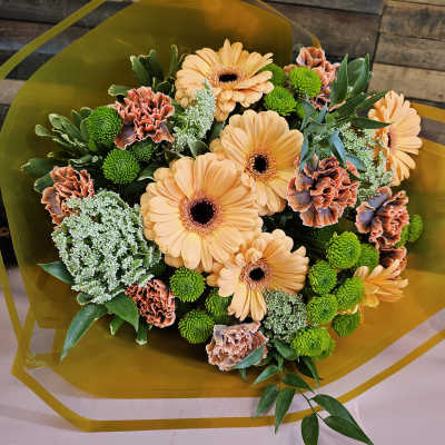 Bouquet of peach gerbera daisies and green button mums with orange carnations