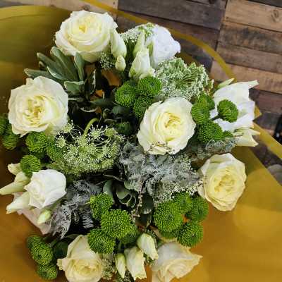 Bouquet of white roses and green button mums wrapped in gold paper