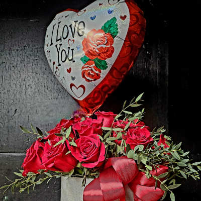 Red rose arrangement in a gray box with a heart-shaped "I Love You" balloon